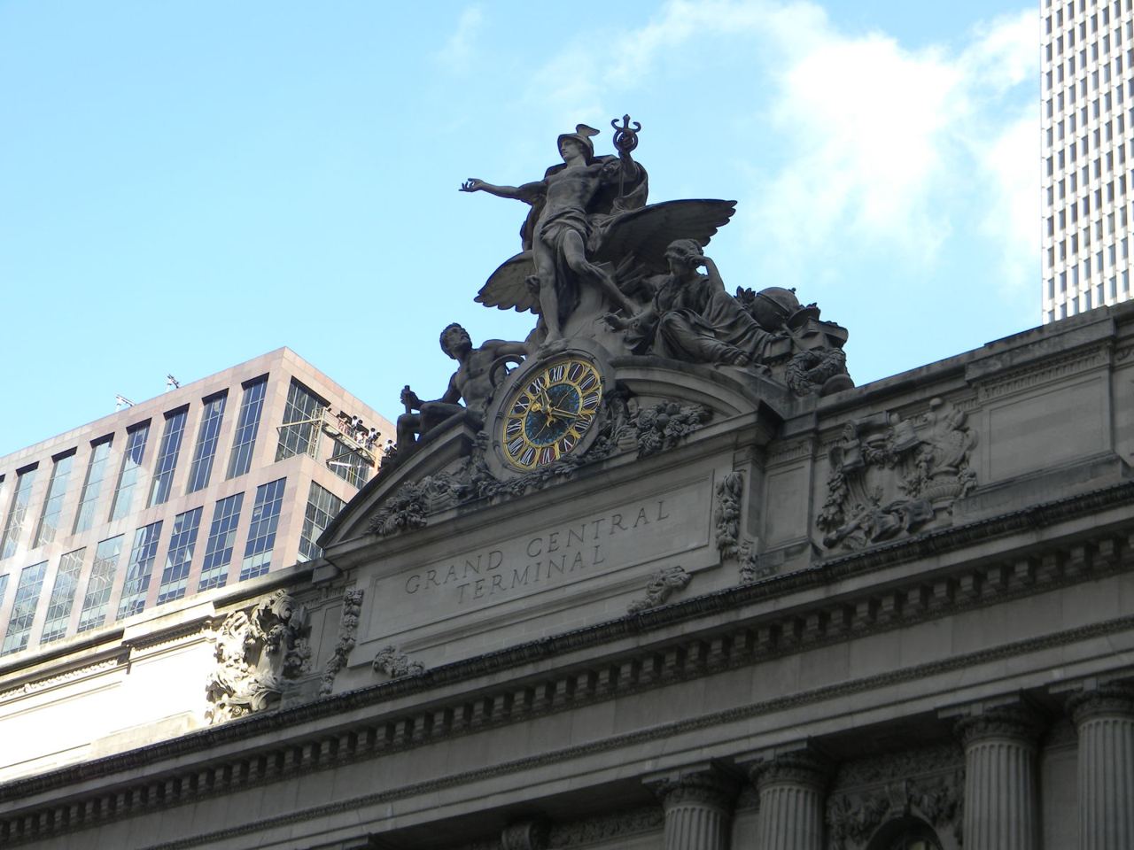 Sousoší a hodiny nad hlavním vchodem Grand Central Terminal proti obloze