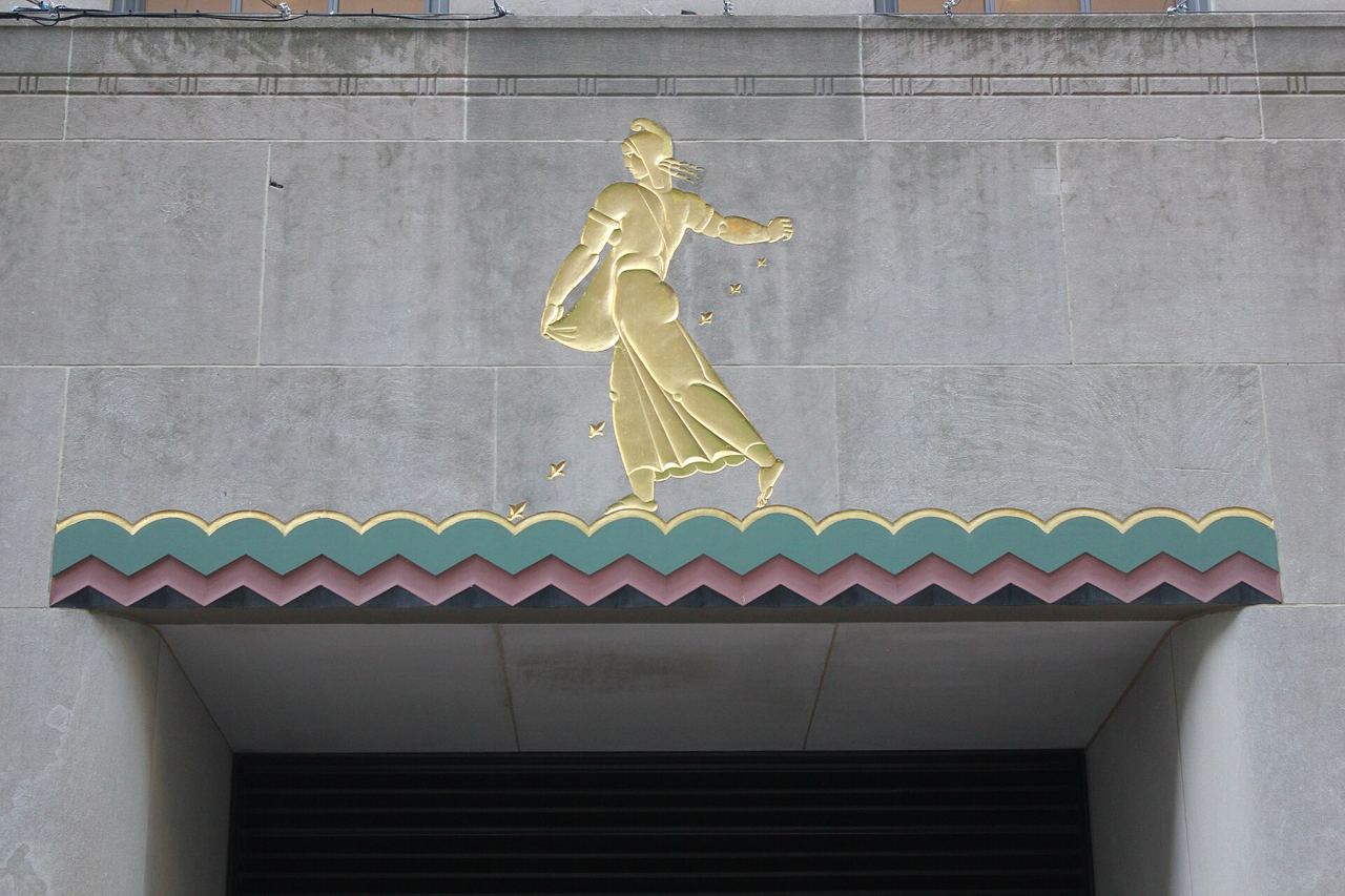 Zlatý reliéf postavy nad vchodem budovy v Rockefeller Center, ukázka art deco detailu